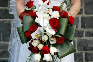Trailing wedding bouquet with red roses with phalaenopsis orchids