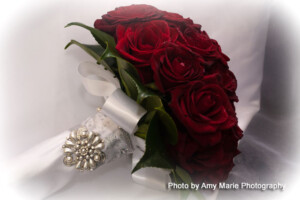 Red roses wedding posie with camellia leaves finished with white ribbon